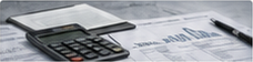 Related-article thumbnail of a calculator and financial paperwork with charts.
