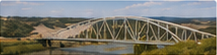 Related-article thumbnail of a long steel truss bridge across prairie terrain.